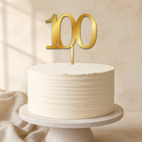 100 Gold Mirror Acrylic cake topper displayed on a cake