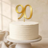 90 Gold Mirror Acrylic cake topper displayed on a cake