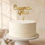 Congrats Grad Gold Mirror Acrylic cake topper displayed on a cake