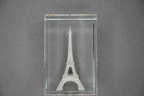 Clear glass block with Eiffel Tower engraving on a gray background