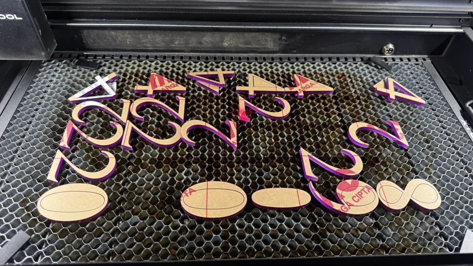 Laser-cut shapes arranged on the workshop cutting bed